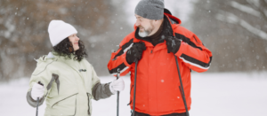 Para starszych ludzi na spacerze z kijkami nordic walking.